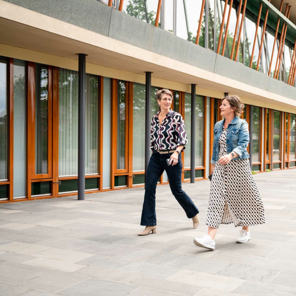 Twee vrouwen lopen langs Gemeentehuis Drimmelen.