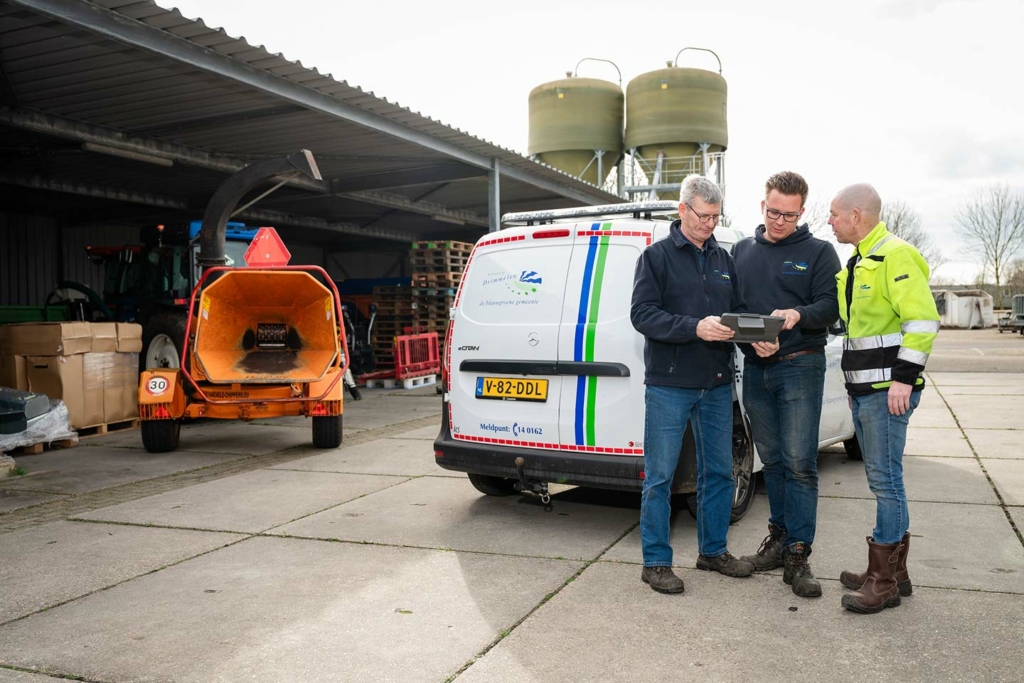 Drie medewerkers op de Gemeentewerf nemen informatie door op een tablet.