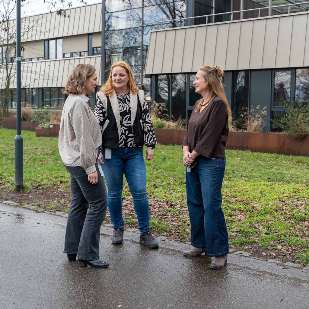 Drie vrouwen in gesprek, buiten bij het gemeentehuis.